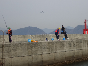 釣り体験をする子どもたちの広報を飛ぶ4機の飛行機