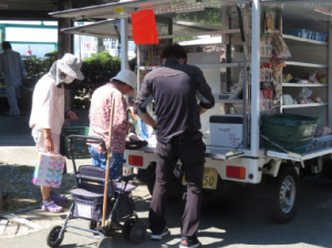 移動販売車で買物をしているお客さんです