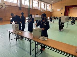生徒が投票箱に投票している様子